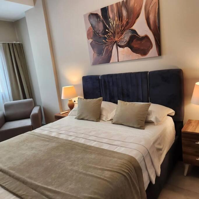 a bedroom with a bed and a chair and a painting at Traumhaus mitten in der City 60 Meter zum Meer in Kuşadası