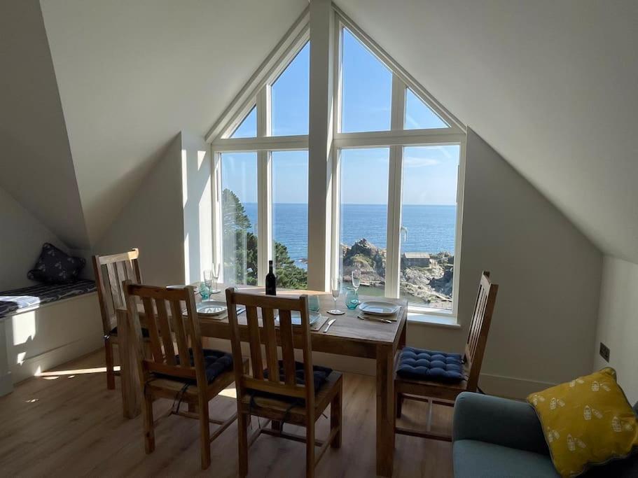 a dining room with a table and a large window at Crow's Nest, Polperro in Polperro