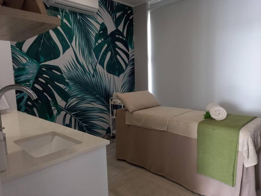 a living room with a couch and a tropical wallpaper at Ballito Hills Lifestyle 1 Bed in Ballito