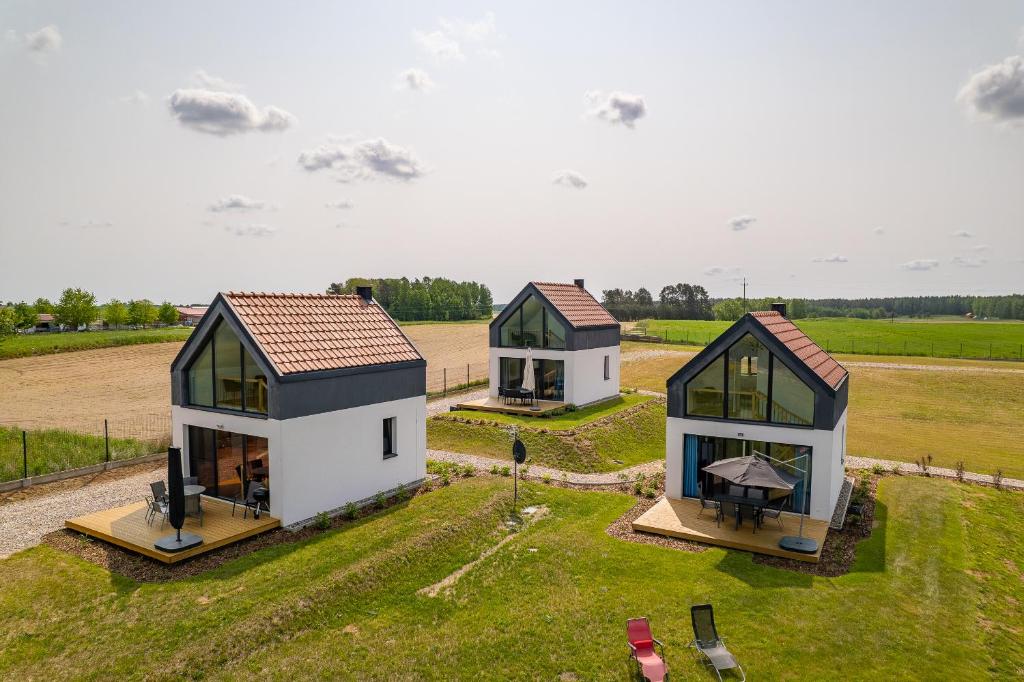 drei kleine Häuser auf einem Feld mit Gras in der Unterkunft Rybical 42 in Rybical