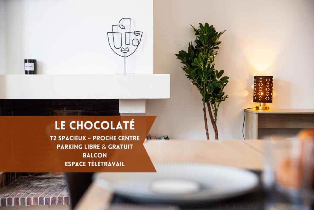 a living room with a table and a sign at Le chocolaté ~ Grand T2 gourmand in Vierzon