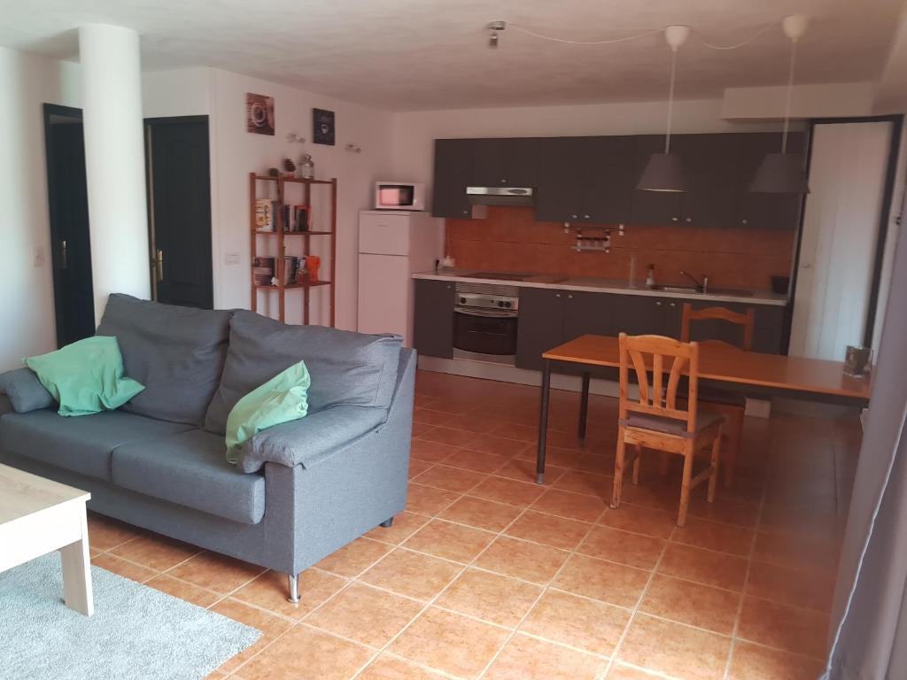 salon z kanapą i stołem oraz kuchnia w obiekcie Alojamiento único y tranquilo Arico con fibra optica w mieście Lomo de Arico