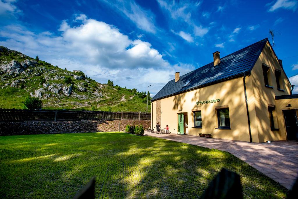 a building with a grassy yard in front of it at WYWIAŁOWO in Olsztyn