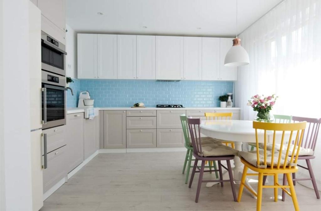 a kitchen with white cabinets and a table and chairs at Casa Good Vibes in Târgu-Mureş