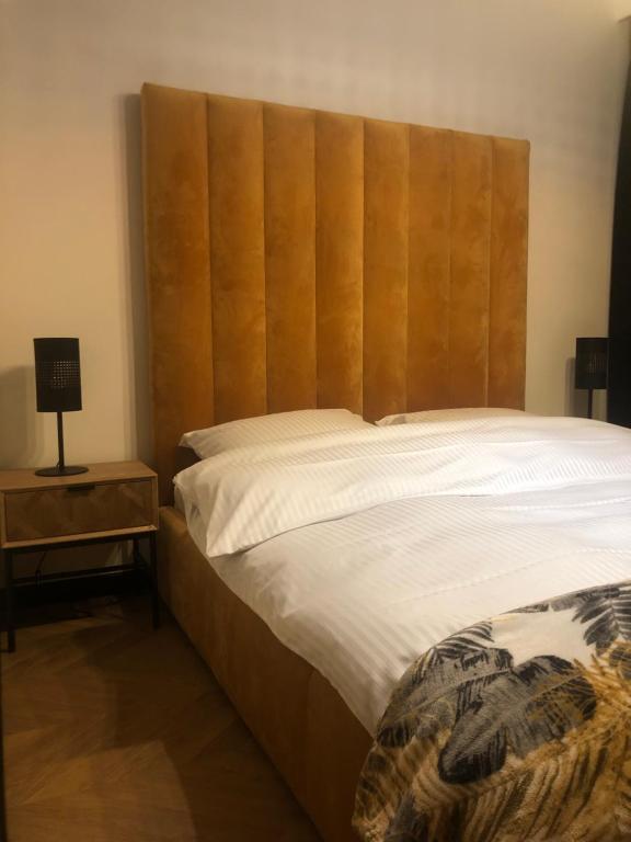 uma cama com uma grande cabeceira de madeira num quarto em Solankowa Aleja Apartament Rodzinny em Inowrocław