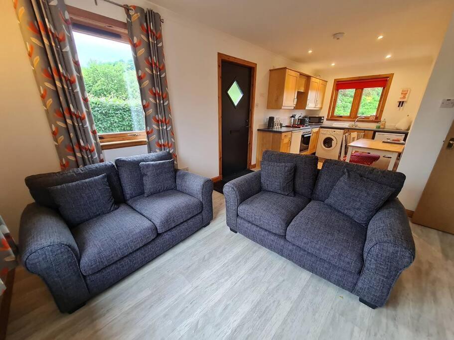 sala de estar con 2 sofás y cocina en Kings Reach - Dunadd Cottage en Kilmichael Glassary