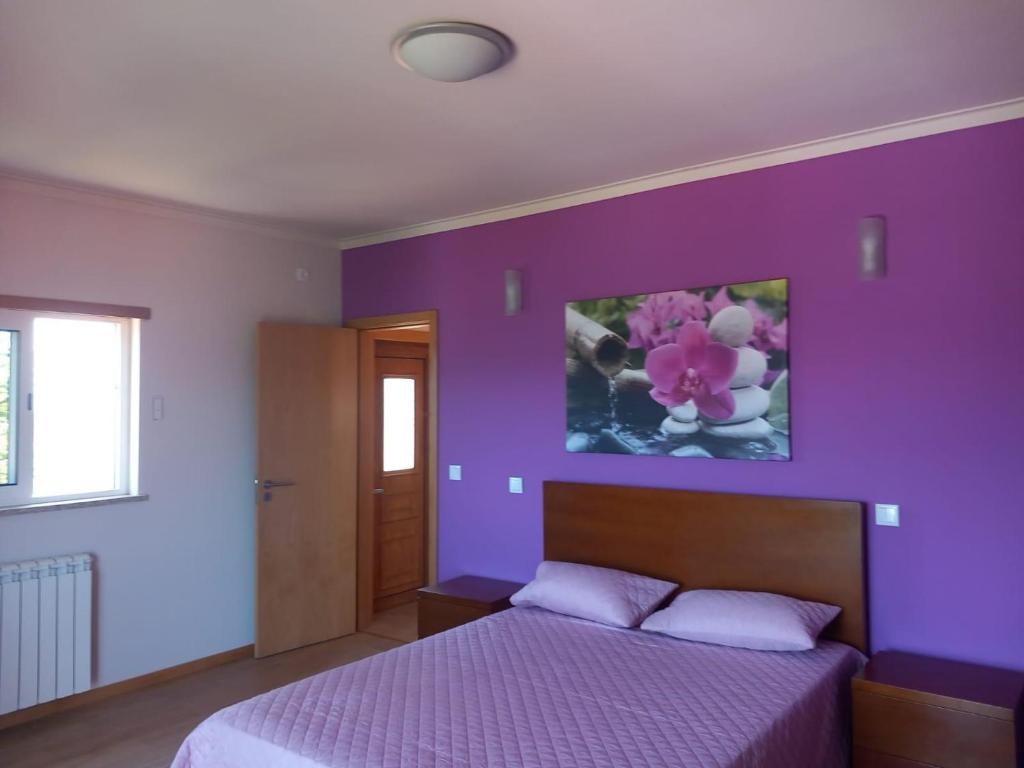 a purple bedroom with a bed with a purple wall at Casa da Bela Vista in Braga