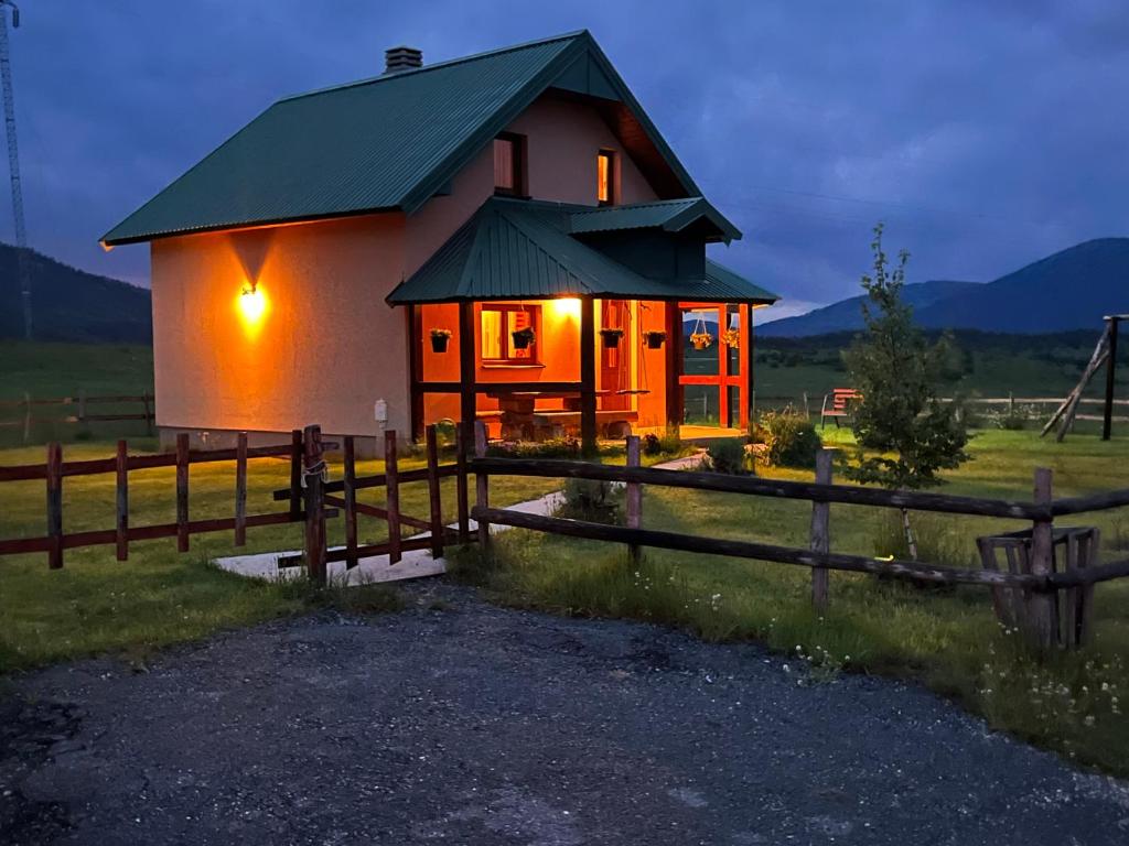 una pequeña casa en un campo con una valla en Vacation Home Andjelic en Žabljak