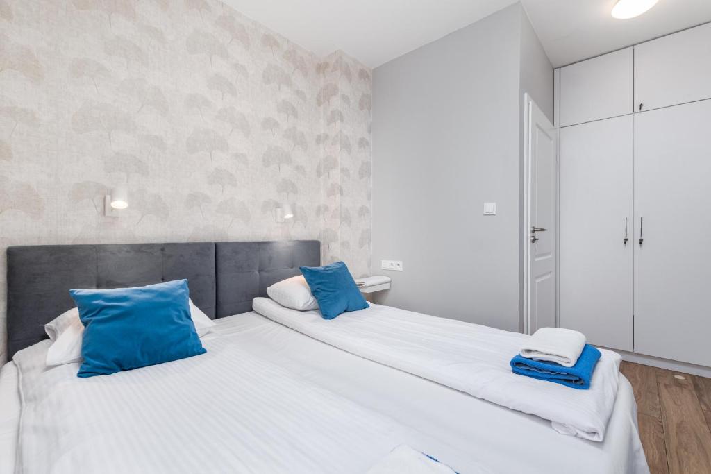 a bedroom with two large beds with blue pillows at Chłodna Apartment by Your Freedom in Warsaw