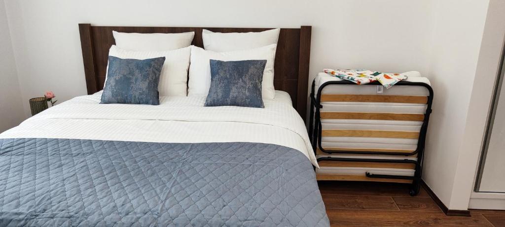 1 dormitorio con 1 cama grande con almohadas azules en Apartman Modiano en Vrnjačka Banja