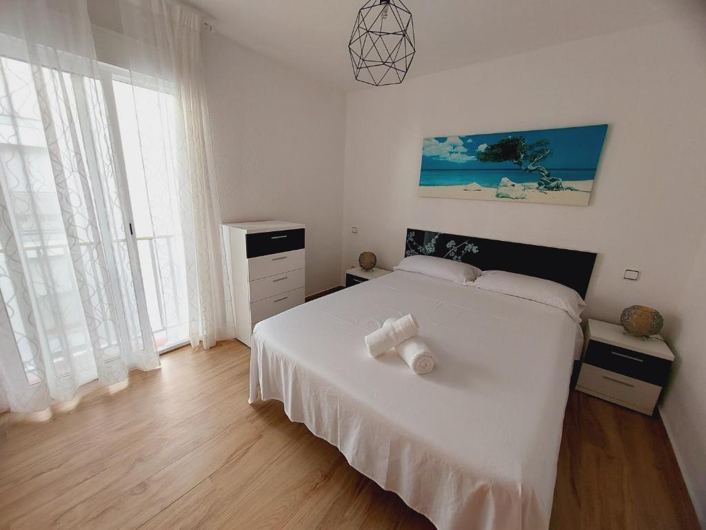 a bedroom with a white bed with two white towels on it at CalafellBeach.SeaViews,New in Calafell