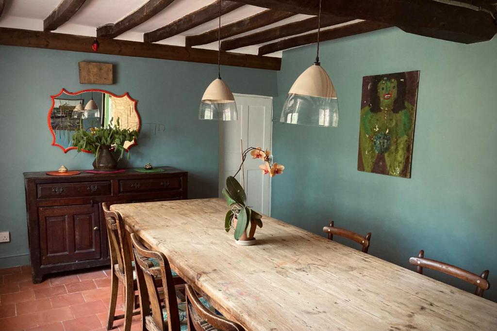 een eetkamer met een houten tafel en stoelen bij Whichford Mill-large Cotswold Home in Shipston on Stour