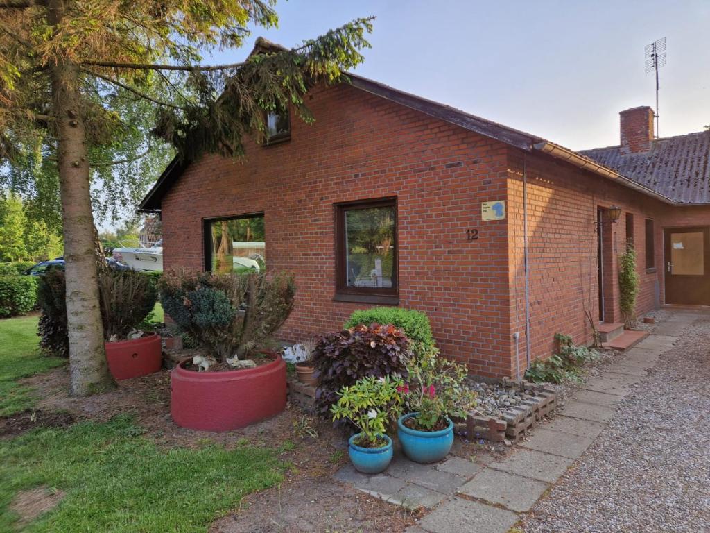 une maison en briques avec des plantes en pot devant elle dans l'établissement Guest House Rens, à Bylderup-Bov