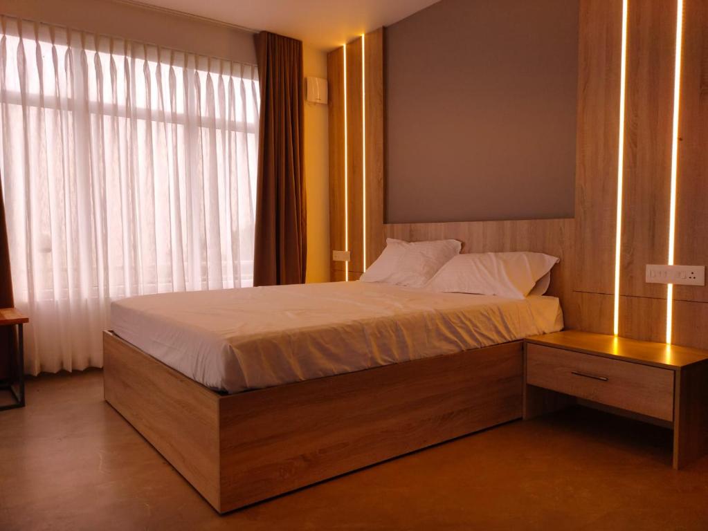 a bedroom with a large bed with a window at Castra villas in Vandiperiyār