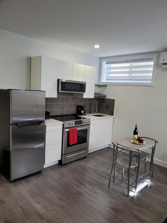 a kitchen with stainless steel appliances and a table at Studio sous-sol Lachine 10 min de DT in Montreal