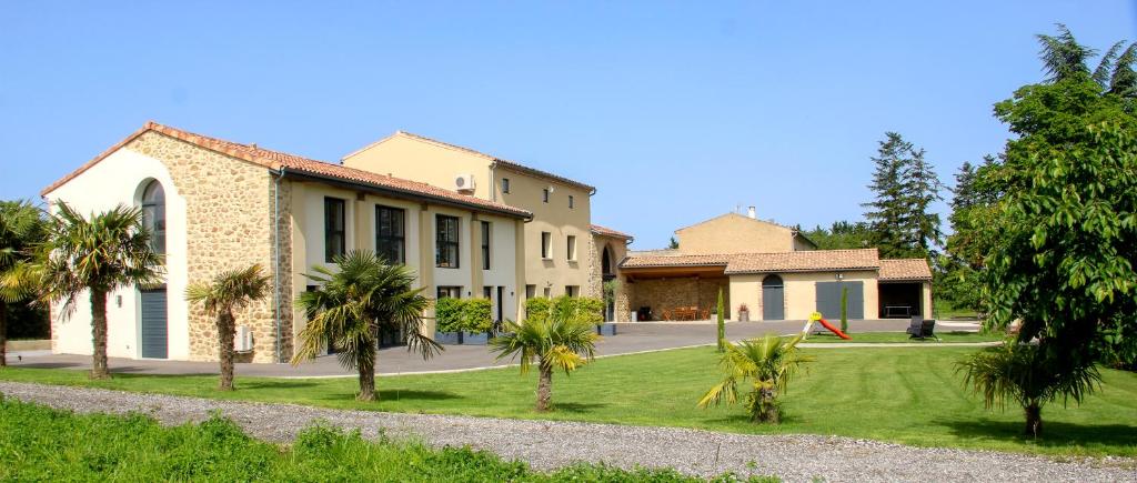 a building with palm trees in front of it at Domaine des Marronniers in Tourtrol