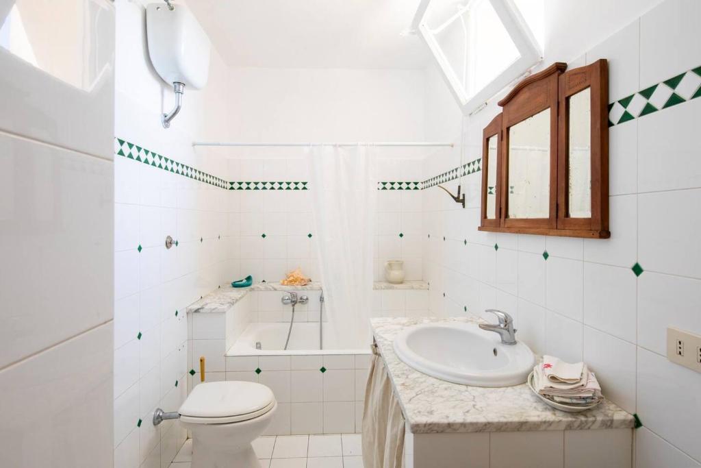 uma casa de banho branca com um lavatório e um WC em Mirella & Patrick in Rome em Boccea