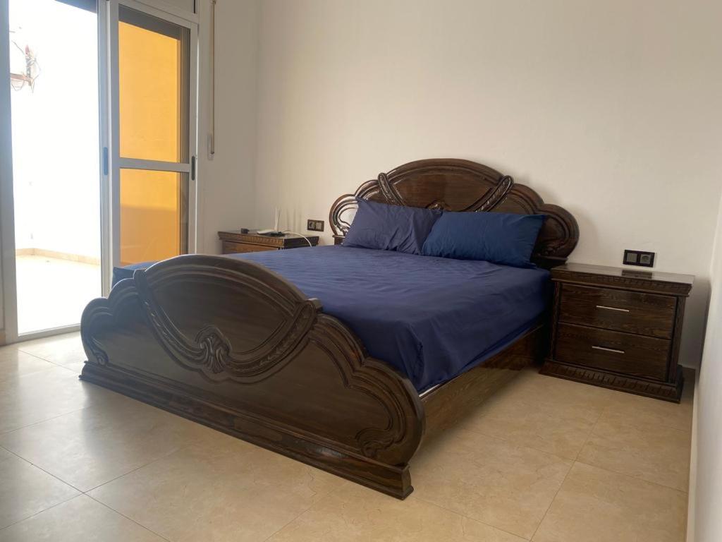 een slaapkamer met een groot houten bed en een dressoir bij CABO CHICO 
