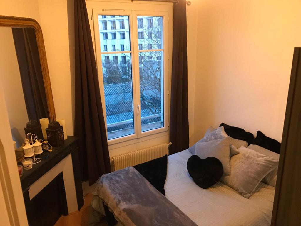 a bedroom with a bed in front of a window at Appartement 60 m², porte de Saint-Cloud in Boulogne-Billancourt