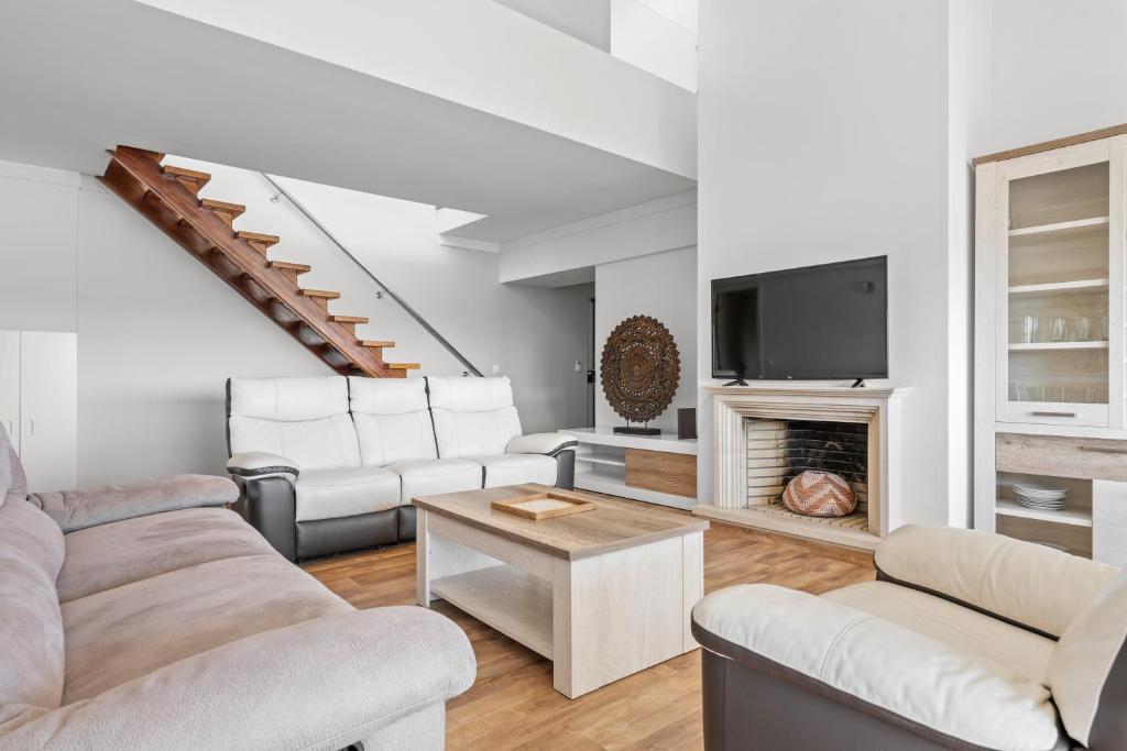 Cascais Terrace في كاسكايس: غرفة معيشة بأثاث أبيض وموقد