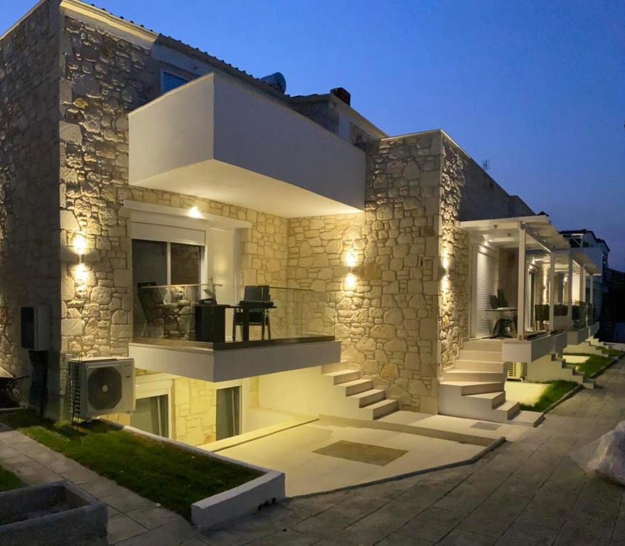 una grande casa in pietra con luci sopra di Sun & Stone House a Polykhrono