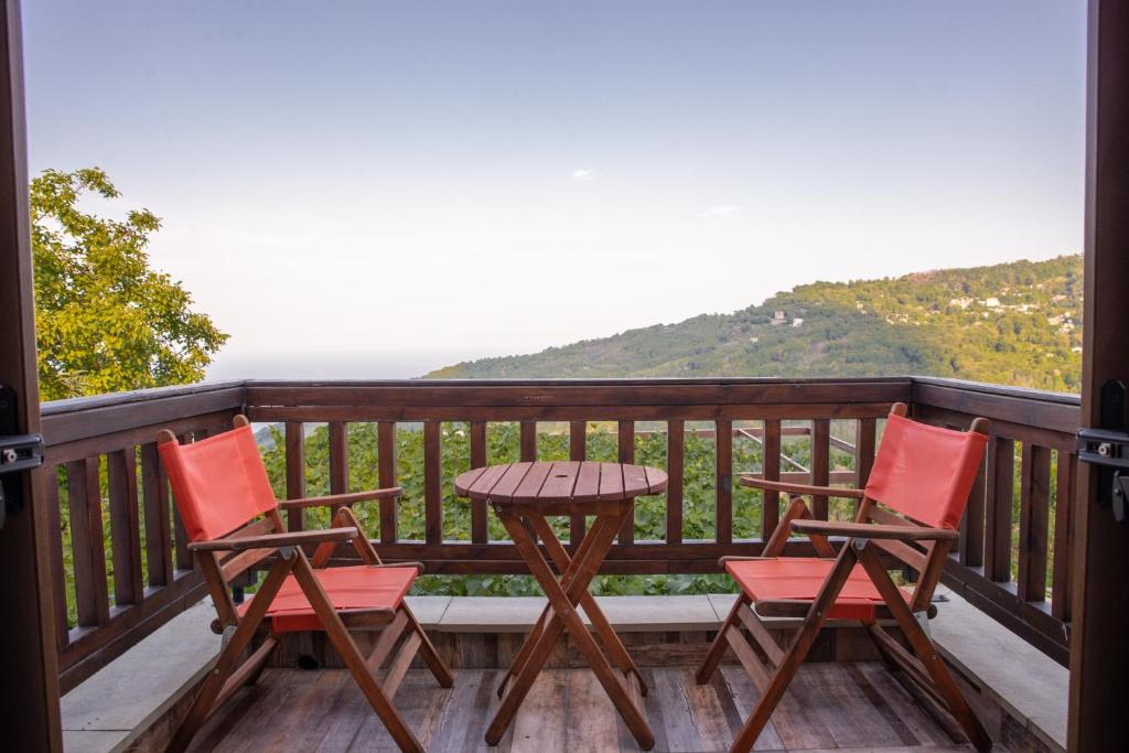 - une terrasse couverte avec 2 chaises et une table sur un balcon dans l'établissement Zoes House, à Makrirrákhi