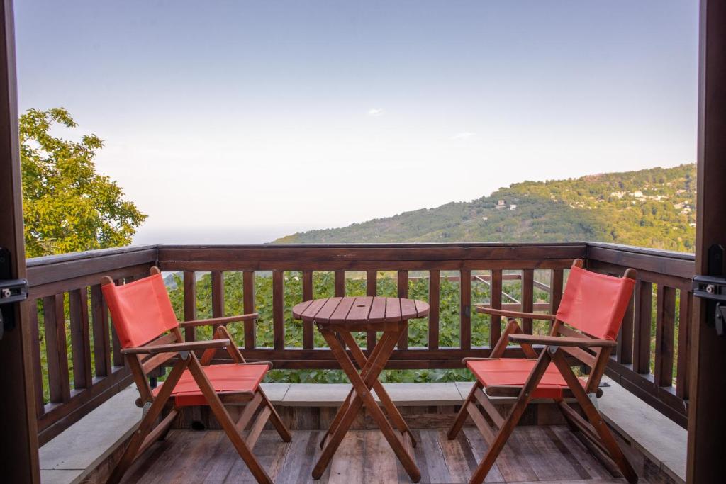 a porch with two chairs and a table on a balcony at Zoes House in Makrirrákhi