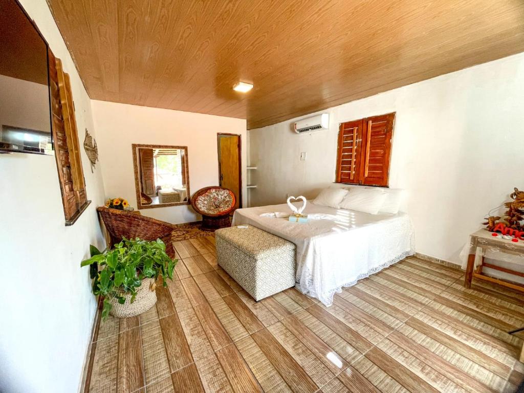 - une chambre avec un lit, une chaise et une table dans l'établissement Pousada Três Lagoas, à Luis Correia