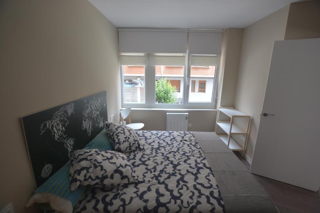 a small bedroom with a bed and a window at El Refugio de Maman in Bilbao