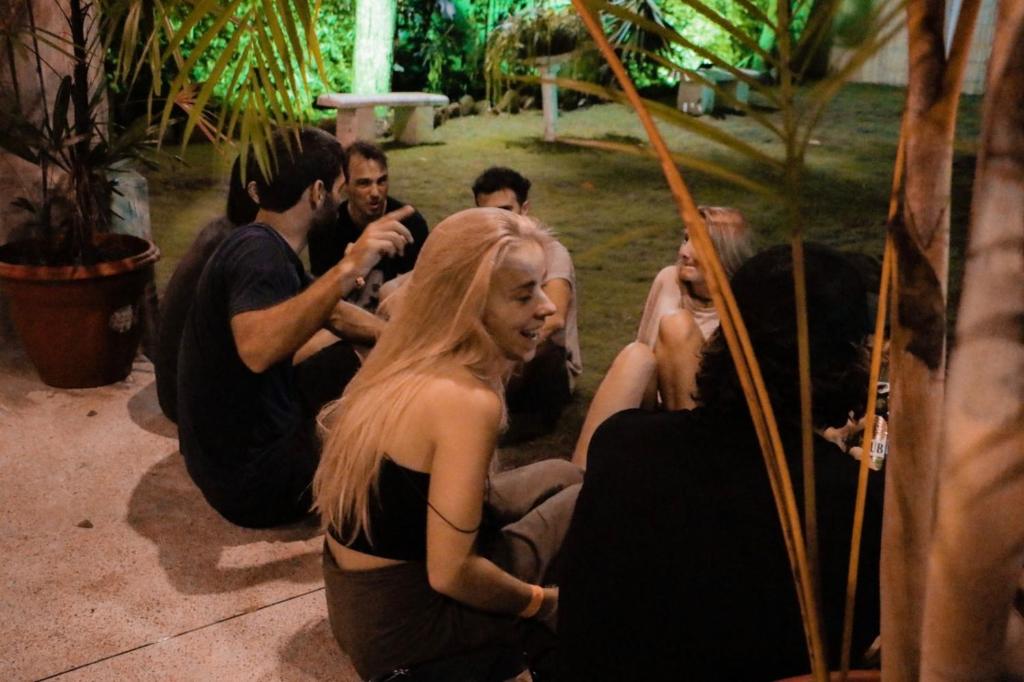 a group of people in black dresses sitting on the ground at Paradise Project Hostal in Montañita