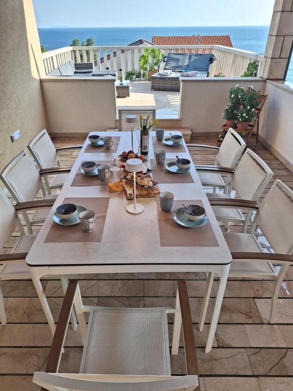 a table on a balcony with a view of the ocean at Apartman K. & M. KOLUMBIĆ in Sveta Nedelja