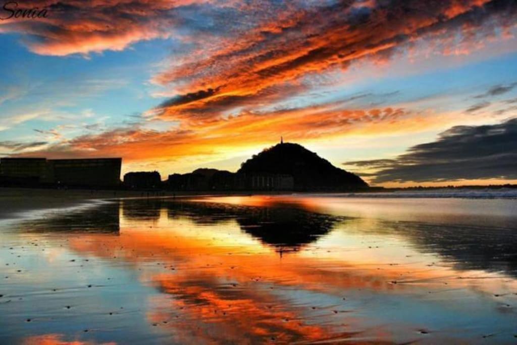 - un coucher de soleil sur la plage avec une réflexion dans l'eau dans l'établissement ALBAOLA APARMENT, à Saint-Sébastien
