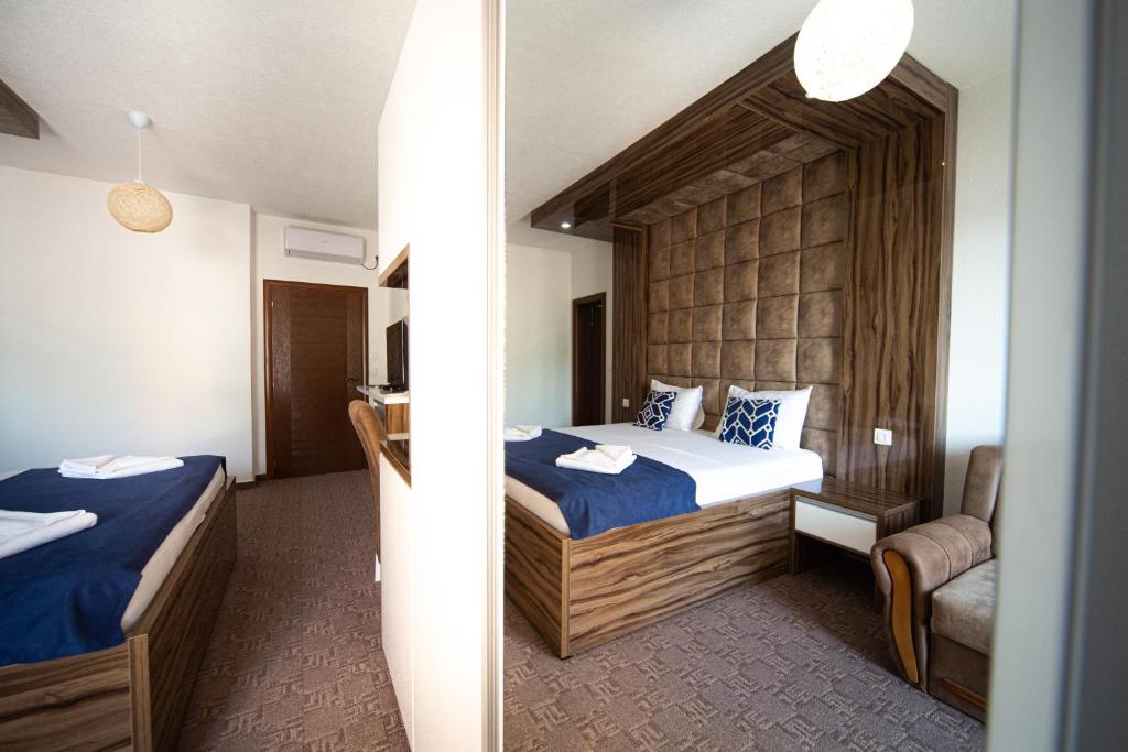 a bedroom with two beds and a chair in it at Hotel &Scaron;ARS in Dobra Voda