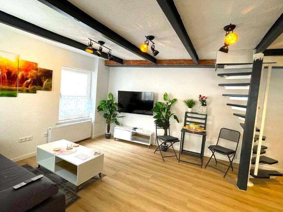 a living room with a staircase and a room with chairs at RobinsHomes-Industrial in Braunschweig