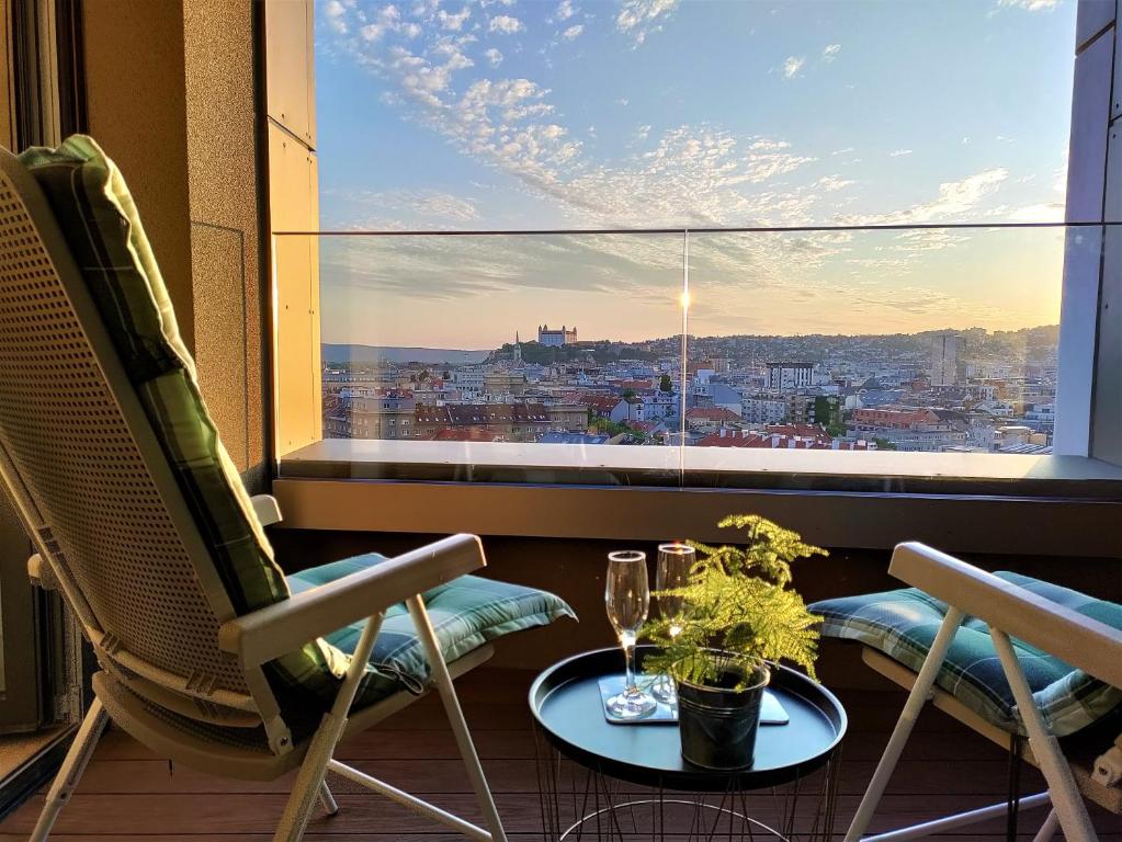 a balcony with two chairs and a table and a window at Cozy 2 rooms flat - Castle view in Bratislava