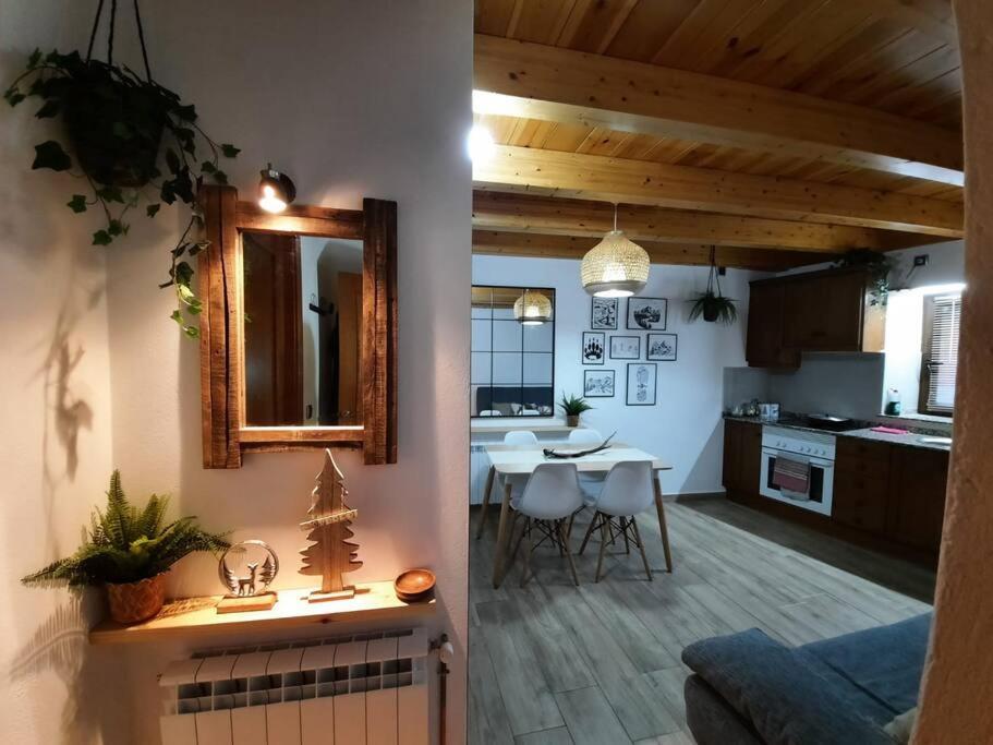 cocina y sala de estar con mesa y espejo en mcastet, casita aranesa en el valle de aran, en Bossòst
