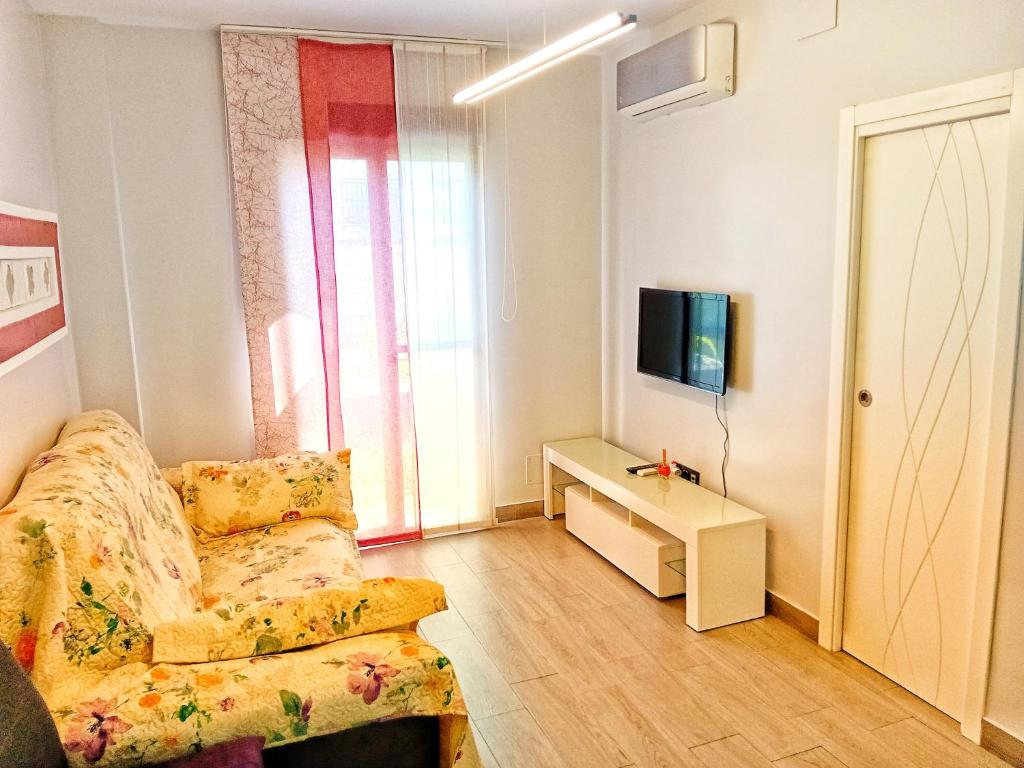ein Wohnzimmer mit einem Sofa und einem TV in der Unterkunft Vacaciones en España in Isla Cristina
