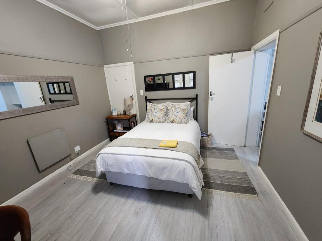 a bedroom with a large bed and a large window at Peony Luxury Room with Wifi and own entrance in Stellenbosch