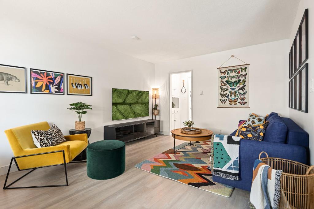 ein Wohnzimmer mit einem blauen Sofa und Stühlen in der Unterkunft East Village Arts District, King Suite with Sofa Bed NRP23-01221 in Long Beach