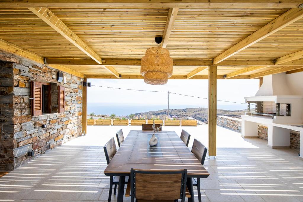 KEA 360 VILLAS- Apollos Alcove في Pisses: غرفة طعام خارجية مع طاولة وكراسي خشبية