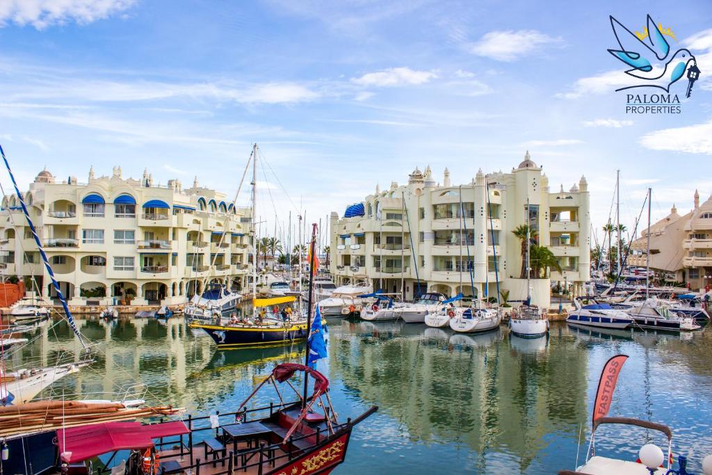 eine Gruppe von Booten, die in einem Yachthafen mit Gebäuden angedockt sind in der Unterkunft Apartment in Puerto Marina with beautiful views of the Sea and the Boats in Benalmádena