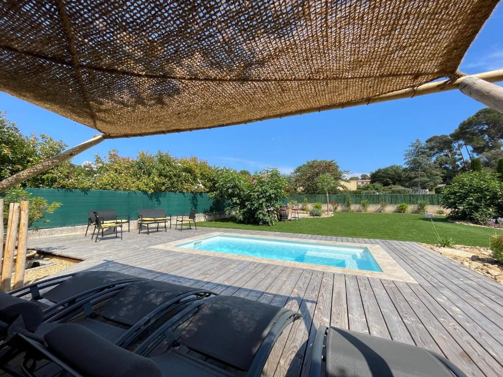 un patio con piscina, mesa y sillas en mas provençale jardin piscine, en Saint-Cyr-sur-Mer