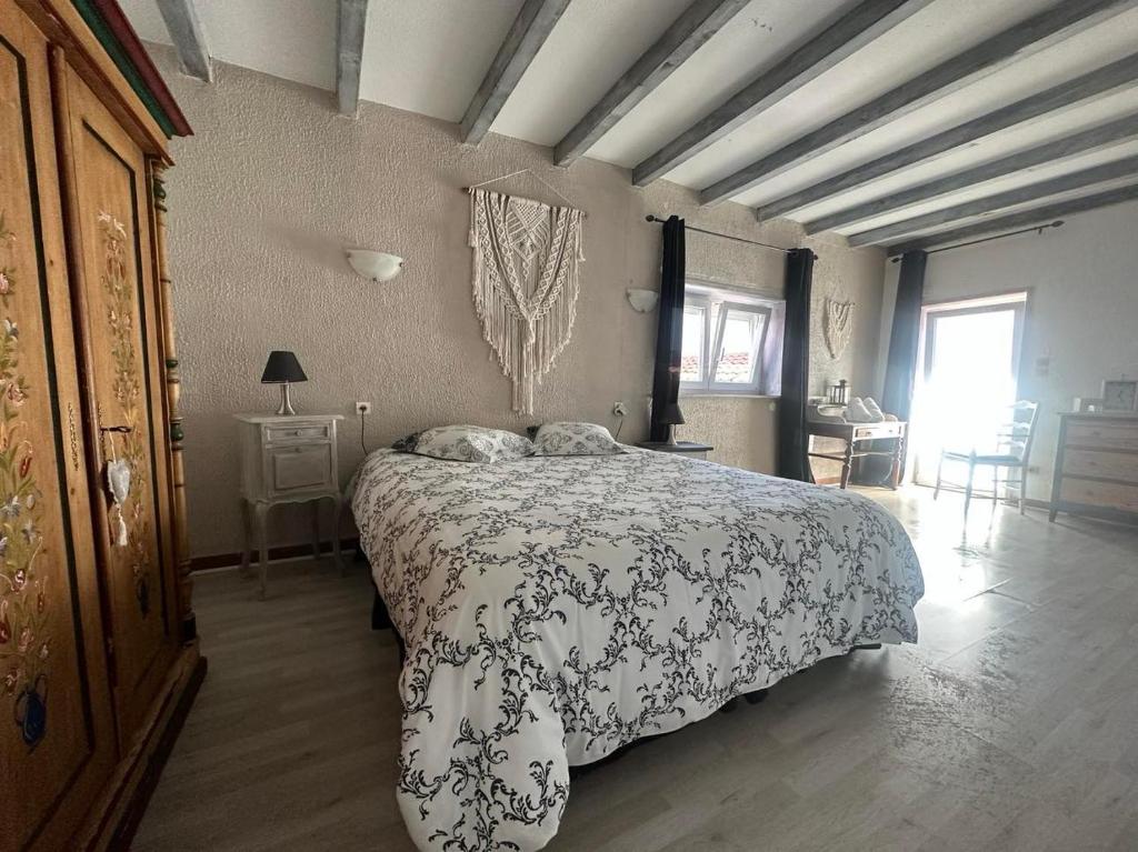 um quarto com uma cama com um cobertor preto e branco em Gîte au Giessen - Loft em Biesheim