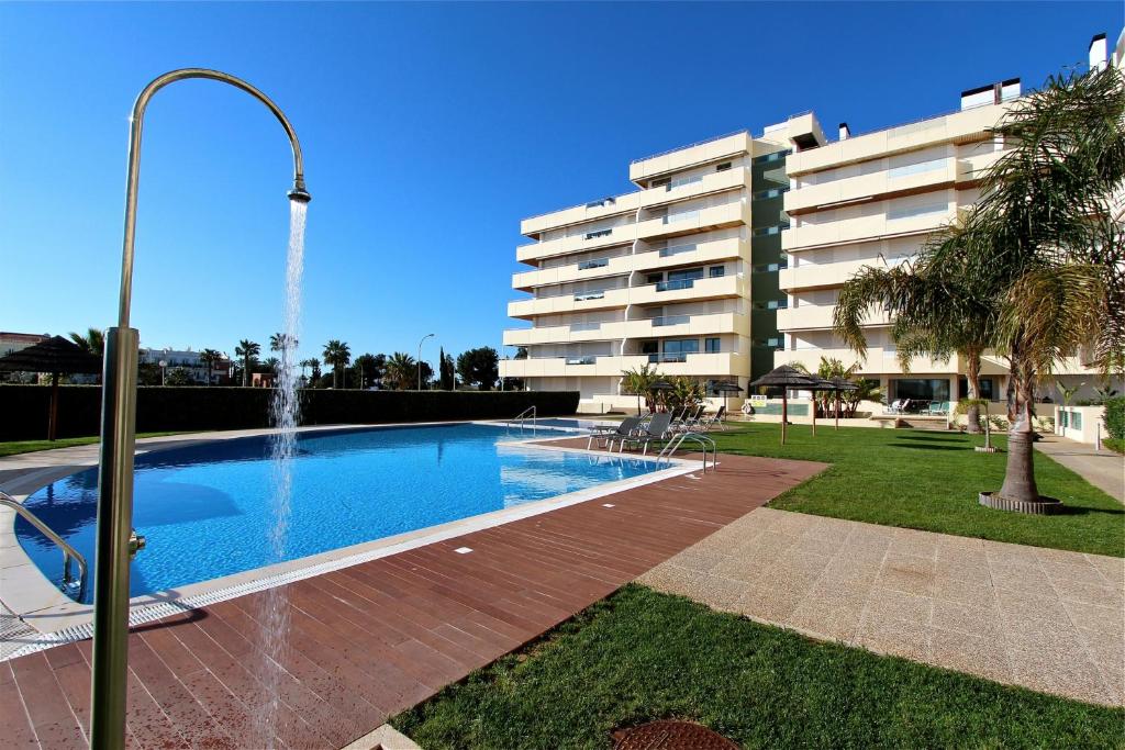 a swimming pool with a fountain in front of a building at Aquamar 15 - Clever Details in Vilamoura