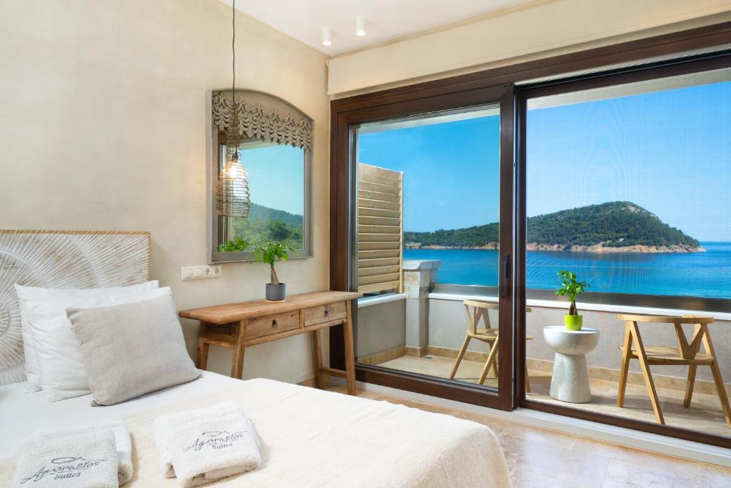 a bedroom with a bed and a view of the ocean at Agorastos Hotel in Koinyra