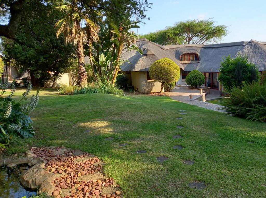 a house with a grass yard with a house at Ekuphumleni Holistic Healing Center in Johannesburg