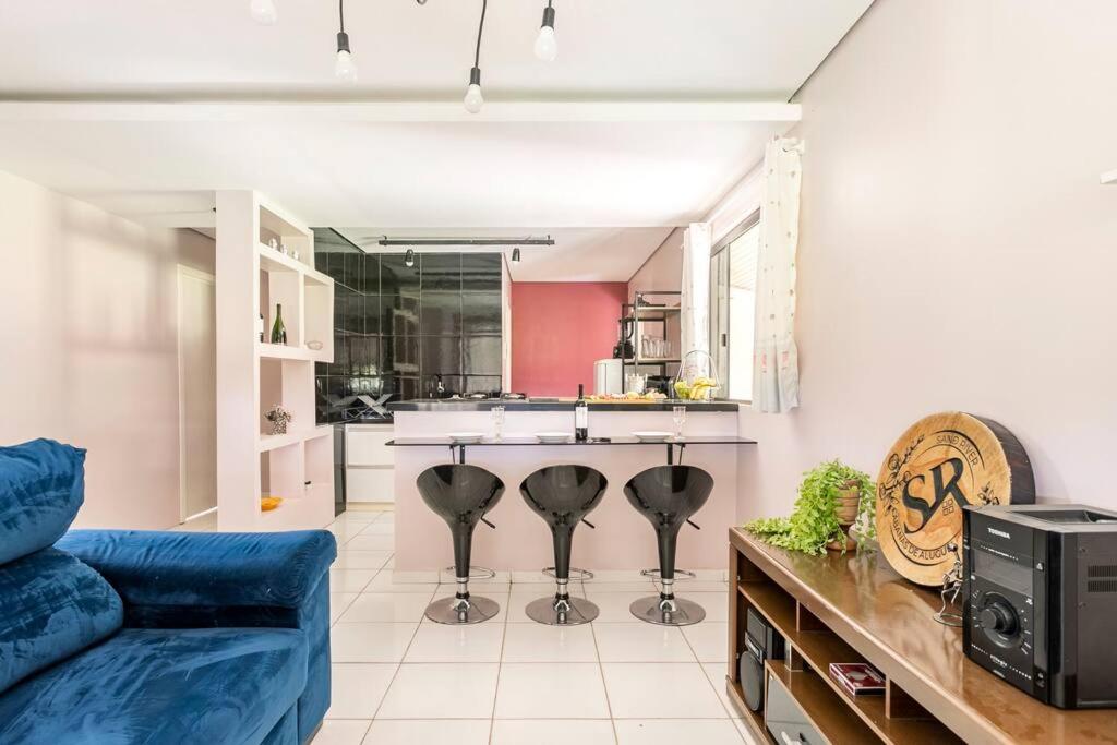 a living room with a blue couch and a kitchen at CASA SERRA CATARINENSE in Rio Rufino