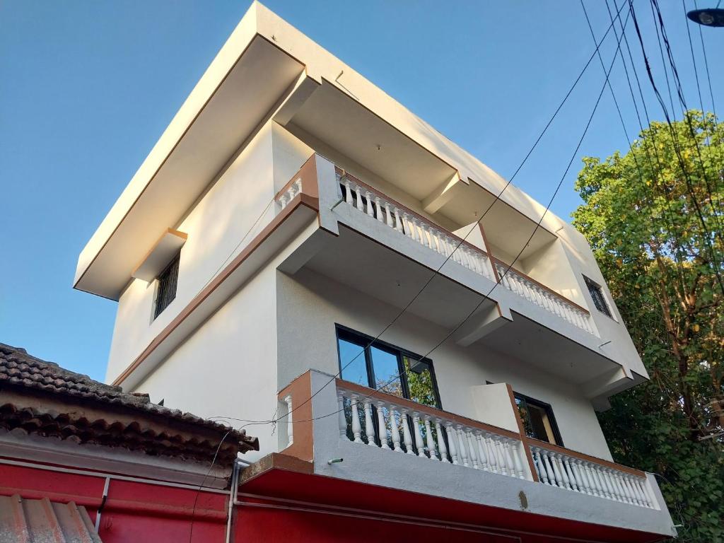 Casa De Menorah في Nerul: منزل أبيض مع شرفة فوقه