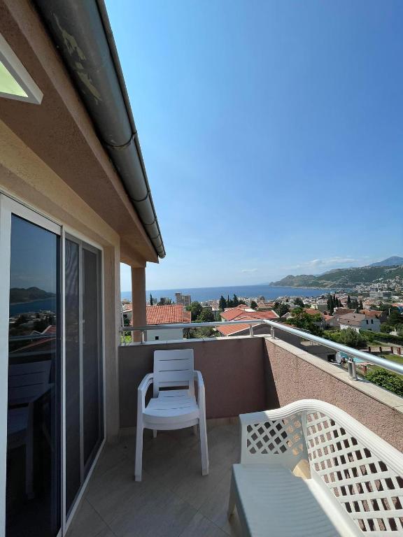 a balcony with a chair and a view of the ocean at Villy Apartments Dobra Voda in Bar