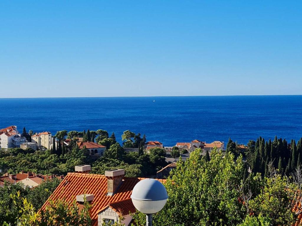 a view of a town with the ocean in the background at SunSpot Apartment - beautiful view with big garden, free parking, central in Dubrovnik